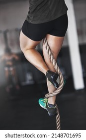 Getting A Foothold. Cropped Shot Of A Young Woman Climbing A Rope At The Gym.