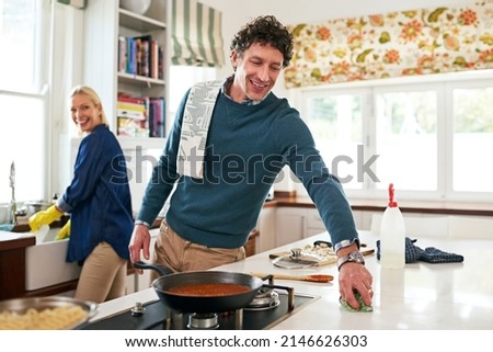Getting a head start on the post-dinner cleanup. Shot of a happy couple cleaning their kitchen together after cooking dinner.