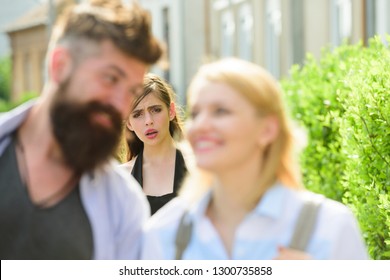Getting her jealous. Romantic couple of man and woman dating. Bearded man cheating his girlfriend with another woman. Unhappy girl feeling jealous. Jealous woman look at couple in love on street.