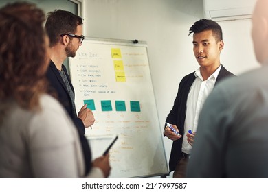 Getting His Team Involved In On Development. Shot Of A Young Man Giving A Presentation To Colleagues In An Office.