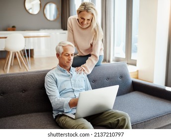 Getting More Out Of Retirement By Staying Current. Shot Of A Mature Couple Using A Laptop On The Sofa At Home.