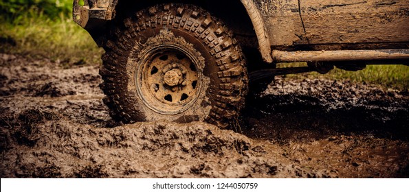 Getting Off The Beaten Path. Car Wheels On Steppe Terrain Splashing With Dirt. SUV Or Offroader On Mud Road. Car Racing Offroad. Offroad Car In Action. Dirty Car Drive On High Speed.