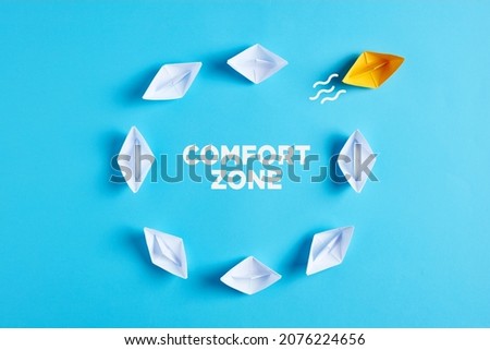 Getting out of the comfort zone concept concept. One paper boat breaks the routine cycle. Imagine de stoc © 
