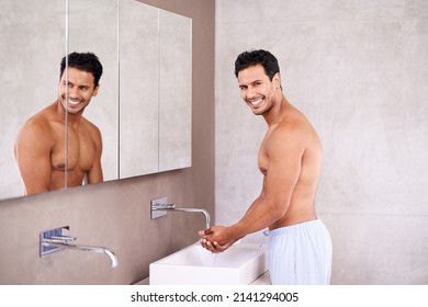 Getting Ready For Bed. Cropped Shot Of A Handsome Young Man Taking Care Of His Skin.