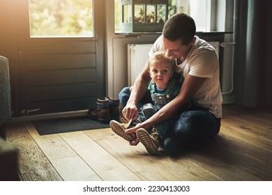 Getting ready for a day out. Shot of a father helping his son put on his shoes at home. - Powered by Shutterstock