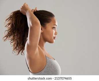 Getting Ready For An Early Morning Jog. A Beautiful Young Woman In Sportswear Tying Up Her Hair.