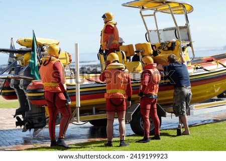 Getting ready to head out. Full length shot of a group of lifeguards preparing to go out to sea on a rescue mission.