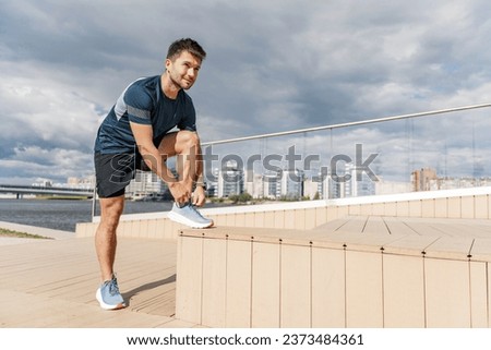 Getting ready for the start corrects running shoes for training. Cardio is a hardy man.  Mental and psychological health when working with fitness exercises. Background sky blue clear day.n Foto stock © 