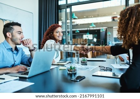 Getting recognition for her exceptional efforts. Shot of businesspeople shaking hands during a meeting in an office.