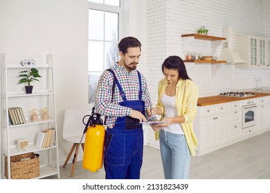 Getting Rid Of Termites Inside House. Indoor Pest Control Exterminator Gives Invoice To Customer. Happy Young Girl Puts Signature On Paper Before Professional With Chemical Spray Takes Care Of Kitchen