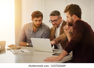 Getting A Second Opinion. Cropped Shot Of Three Businessmen Looking At A Laptop In The Boardroom.