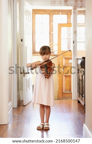 Getting in some violin practive. Shot of a young girl playing violin.