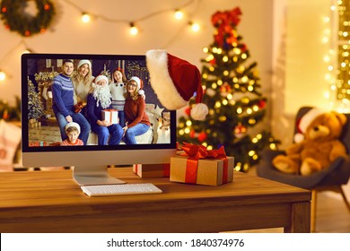 Getting Together With Your Loving Family Is The Best Gift. Computer With Photo Of Happy Parents And Children Reunited For Christmas Set As Desktop Background Standing On Desk In Cozy Room