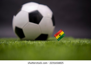 Ghana flag and soccer ball on the football field. Football classic black and white ball on background. Sports Competition. The national flag of the country. Green fresh lawn grass - Shutterstock ID 2231656825