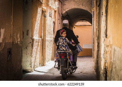 GHARDAIA, ALGERIA - April 4, 2017: Old man with motorcycle and his two granddaughters on the old street of Ghardaia ancient town, M'Zab Valley, Algeria