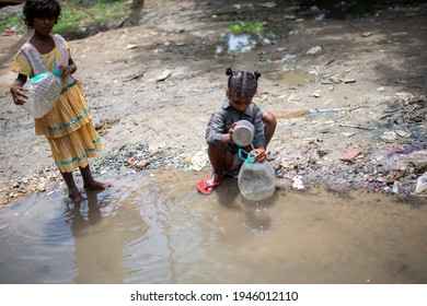 Ghaziabad, Uttar Pradesh, India: 21 August 2020: Slum Children Filled Water Container From Road Side Small Pond, Made By Leakage Of Water From Water Supply Pipeline. 