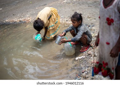 Ghaziabad, Uttar Pradesh, India: 21 August 2020: Slum Children Filling Water In Plastic Container From Road Side Small Pond, Pond Made By Leakage Of Water From Water Supply Pipeline. 