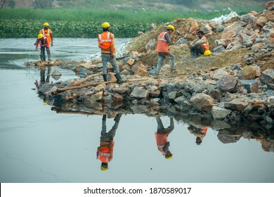 Ghaziabad, Uttar Pradesh, India- December 7 2020: Construction Workers Diverting The Water Flow In River Hindon.