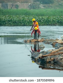 Ghaziabad, Uttar Pradesh, India- December 7 2020: Construction Workers Diverting The Water Flow In River Hindon. 