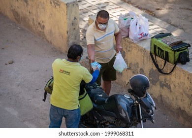 Ghaziabad, Uttar Pradesh, India-April 4 2021: A BigBasket Delivery Boy Delivering A Food Order To Coustumer,  Amid Covid  Lockdown In India,  Emergency Services During Pandemic