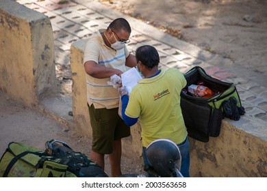 Ghaziabad, Uttar Pradesh, India-April 4 2021: A BigBasket Delivery Boy Delivering A Food Order To Coustumer,  Amid Covid  Lockdown In India,  Emergency Services During Pandemic