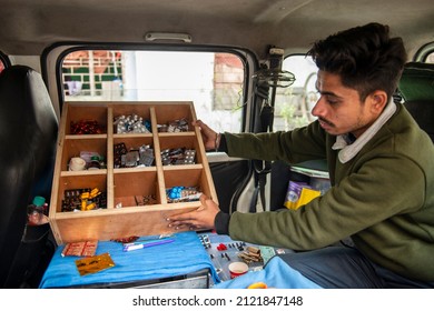 Ghaziabad, Uttar Pradesh, India-Jan 19 2022: Man Sitting Inside The Vehicle Showing Medicine Box, Charitable Mobile Clinic Where Doctor Give Medicine At Very Marginal Price