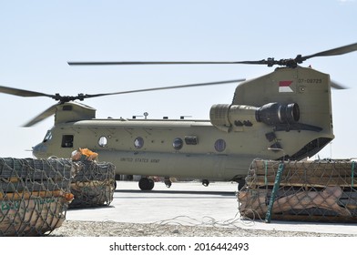 GHAZNI, AFGHANISTAN - April 5, 2011: A US Army Boeing CH-47 Chinook Sits On A Airfield Surrounded By Supplies That Prepared To Be Sling Loaded  To Another Location During The War In Afghanistan.