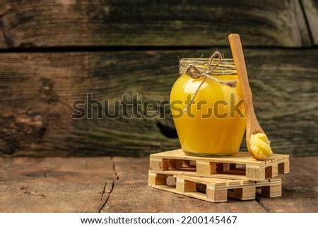 ghee oil. Ghee or clarified butter in jar on a wooden background. banner, menu, recipe place for text.