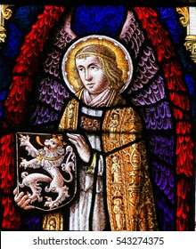 GHENT, BELGIUM - DECEMBER 23, 2016: Stained Glass window depicting an Angel holding the Flemish Lion in the Cathedral of Saint Bavo in Ghent, Flanders, Belgium.