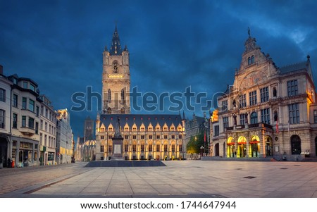 Ghent, Belgium. Sint-Baafsplein square at dusk with building of historic Town Hall and famous Belfry of Ghent