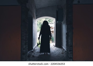 Ghost In Abandoned, Haunted House. Horror Scene Of Spooky Silhouette Holding Old Axe, Halloween Concept.