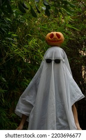 Ghost Costume With A Sheet, With Sunglasses On And A Pumpkin On Top Of The Head