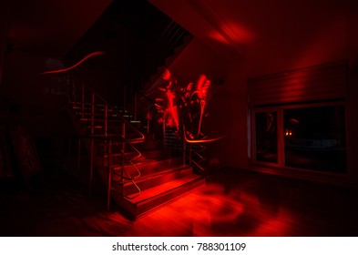 Ghost In Haunted House At Stairs, Mysterious Silhouette Of Ghost Man With Light At Stairs, Horror Scene Of Scary Ghost Spooky Llights . Scary Hall. Halloween Background.