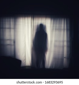 The ghost shadow standing behind the door curtain and looked into the room, blurred image.