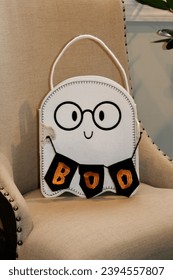 A ghost shaped trick or treat bag that says "BOO". - Shutterstock ID 2394557807