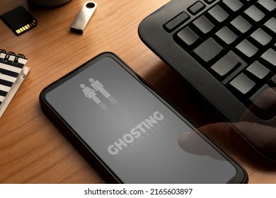 Ghosting concept: smartphone with the word ghosting on display and two disappearing people