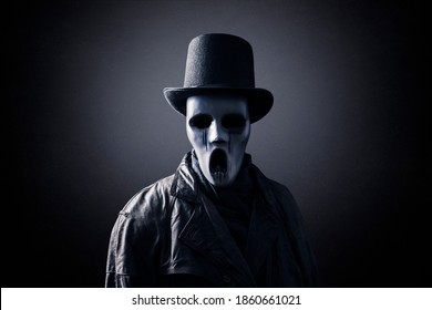 Ghostly figure with extra tall black vintage top hat in the dark