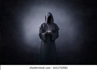 Ghostly figure with light in hands in the dark