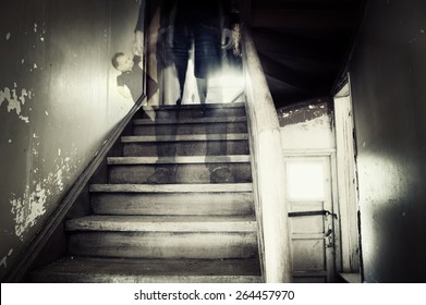 Ghostly figure standing on stairs holding doll 