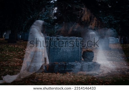 The ghosts roam near the gravestones in the cemetery.