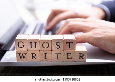 Ghostwriter Wooden Block On Computer Keyboard While Someone Typing