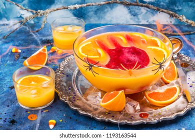 Ghoul's Orange Punch With Bloody Ice Hand In A Glass Bowl On Dark Halloween Background