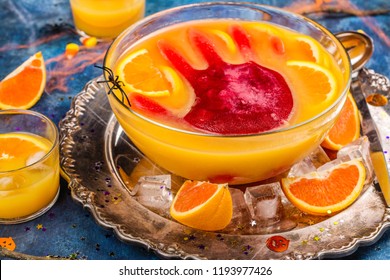 Ghoul's Orange Punch With Bloody Ice Hand In A Glass Bowl On Dark Halloween Background