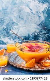 Ghoul's Orange Punch With Bloody Ice Hand In A Glass Bowl On Dark Halloween Background