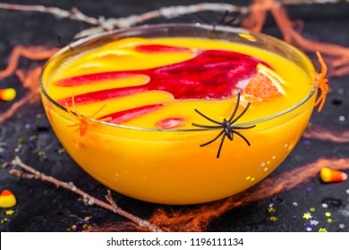 Ghoul's Orange Punch With Bloody Ice Hand In A Glass Bowl On Dark Halloween Background