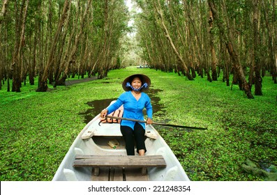 AN GIANG, VIET NAM- SEPT 22: Tra Su Indigo Forest, Eco Tourist Area At Mekong Delta For Green Ecotourism, Friendly Woman Rowing The Row Boat, Hyacinth Cover Water, Tree Flooded, Vietnam, Sept 22, 2014