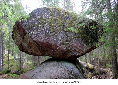 A giant balancing boulder rock in the Finnish forest.