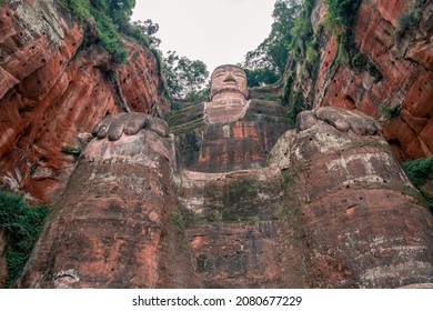The Giant Buddha figure in the middle from below in the Giant Buddha Scenic Area in Leshan, Sichuan, China. View from below, head, hands and knees visible 