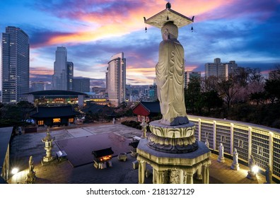 A giant Buddha statue looks out over downtown Seoul at sunset from Bongeunsa Temple, South Korea