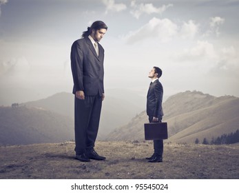 Giant Businessman Observing A Smaller One